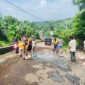 warga turun ke jalan melakukan aksi gotong royong massal untuk memperbaiki kerusakan jalan provinsi